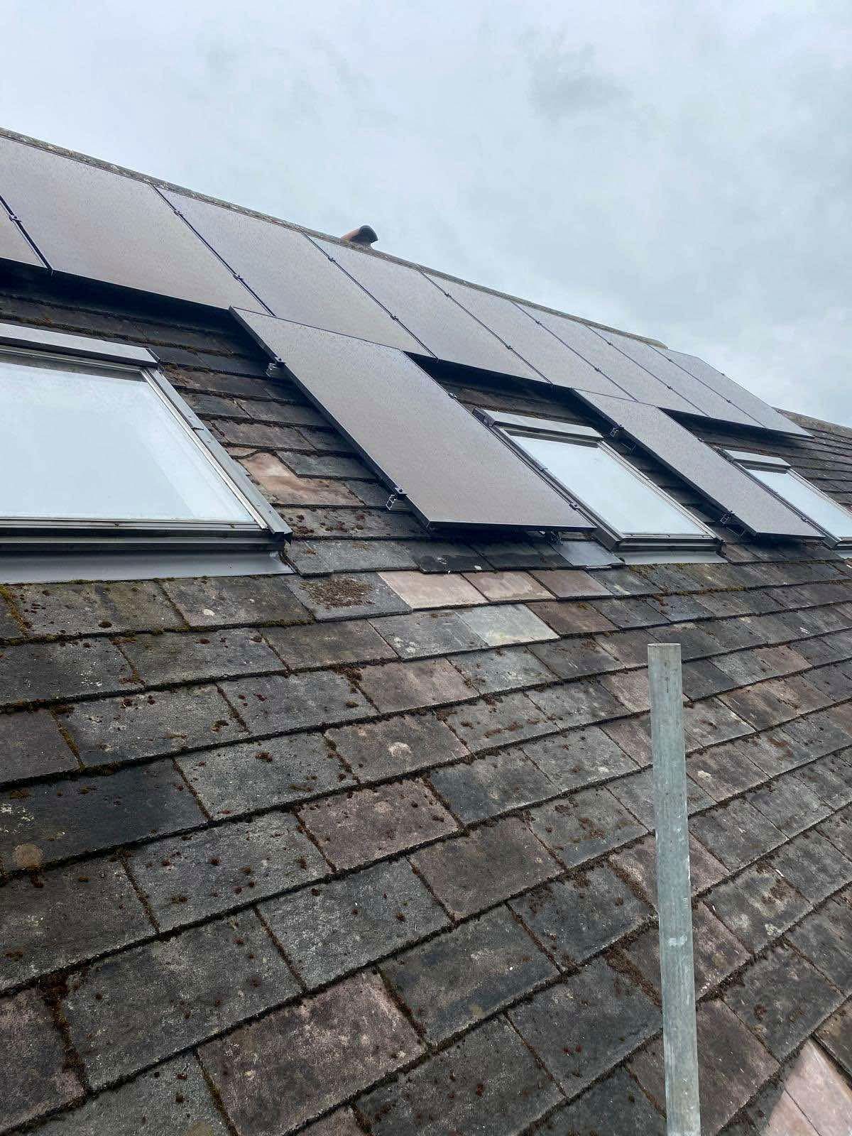 Solar panels fitted around rooflights on a pitched tile roof